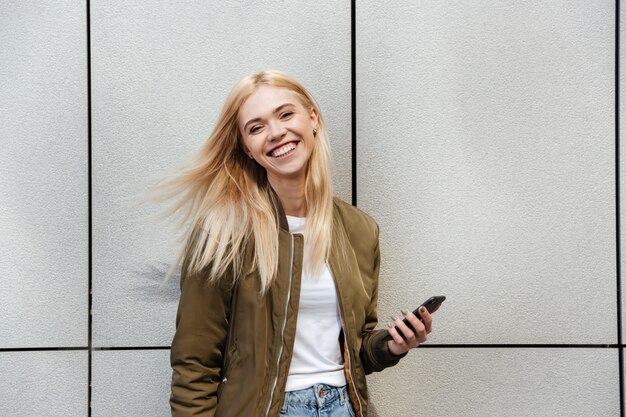 Cheerful woman with smartphone laughing