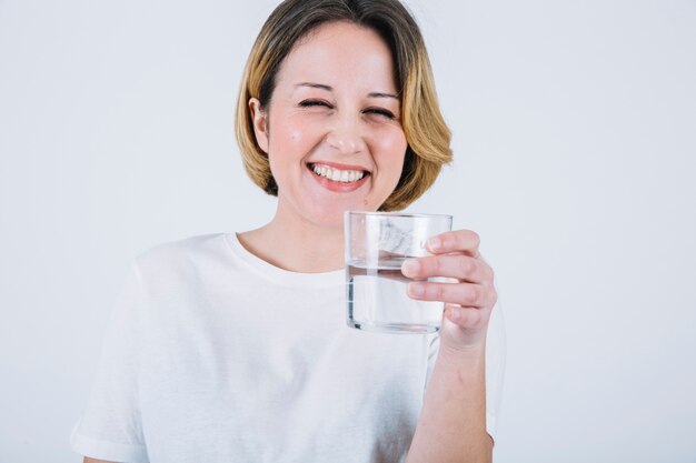 Cheerful woman with water on white background