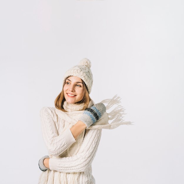 Cheerful woman wrapping scarf around neck