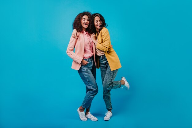 Cheerful woman in yellow jacket dancing in studio