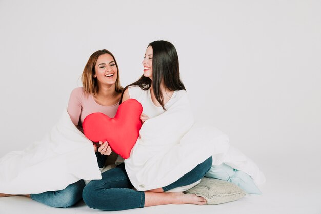 Cheerful women in blanket with heart