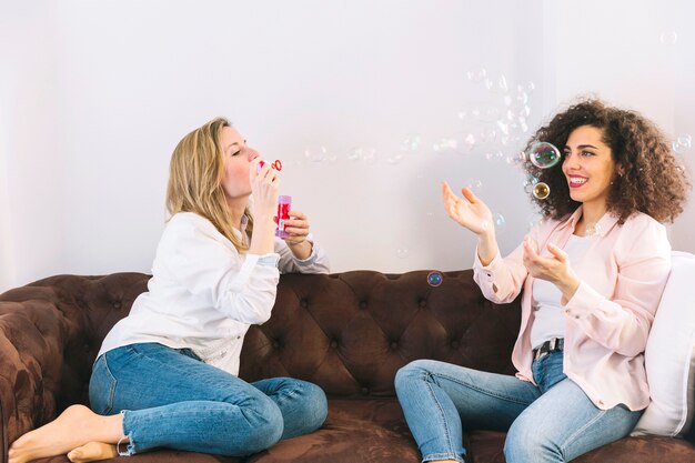 Cheerful women blowing and catching bubbles