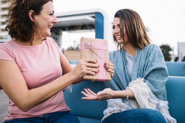 Cheerful women exchanging gifts