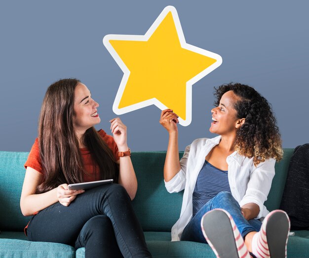 Cheerful women holding a golden star icon