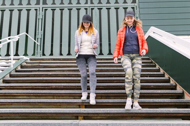 Cheerful women running downstairs on training