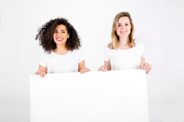 Cheerful women with blank poster