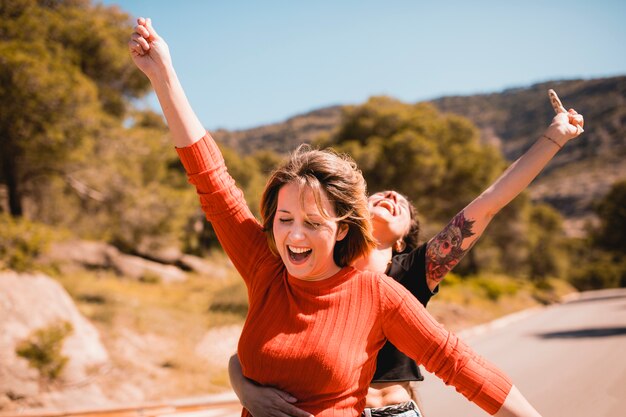 Cheerful women with lollipops near road