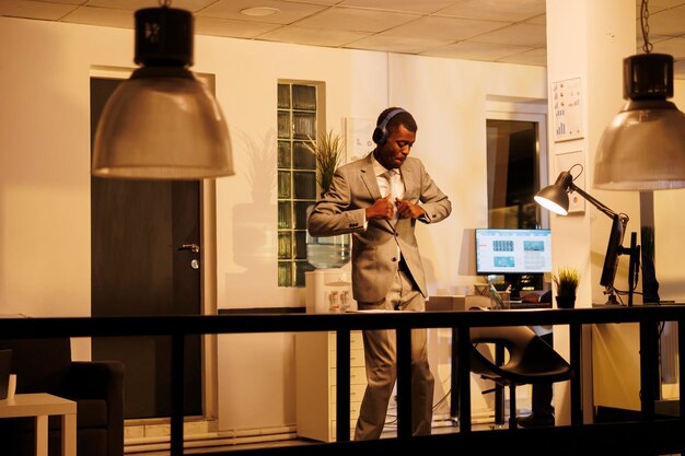 Free photo cheerful worker wearing headphones showing dance moves