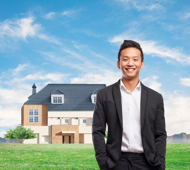 Cheerful worker with modern house background