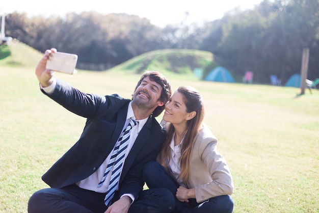 Free photo cheerful workmates taking selfie with mobile phone