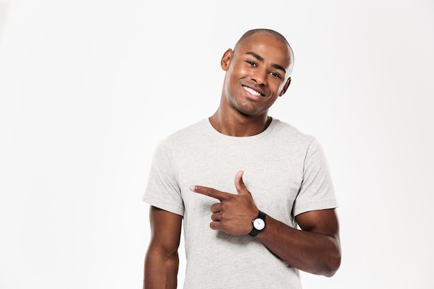 Cheerful young african man pointing.