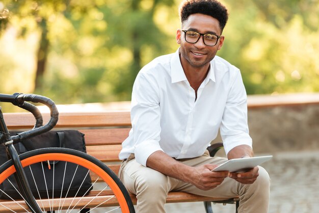 Cheerful young african man using tablet computer.