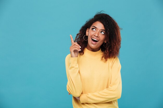 Cheerful young african woman dressed in warm sweater