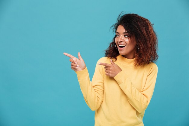 Cheerful young african woman dressed in warm sweater