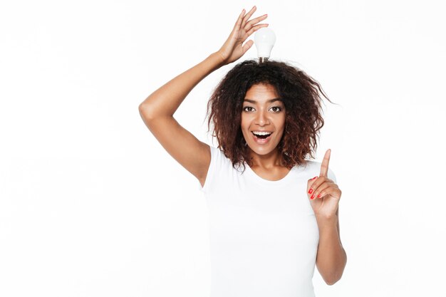 Cheerful young african woman holding lamp have an idea.