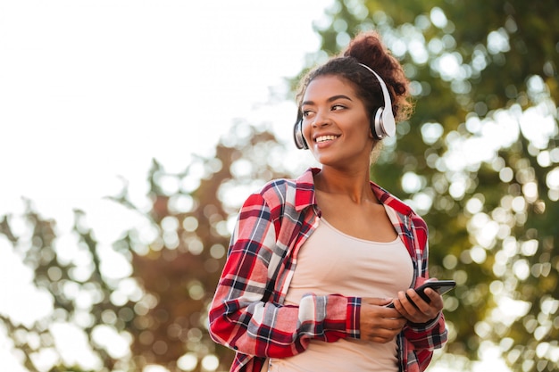 Cheerful young african woman walking outdoors