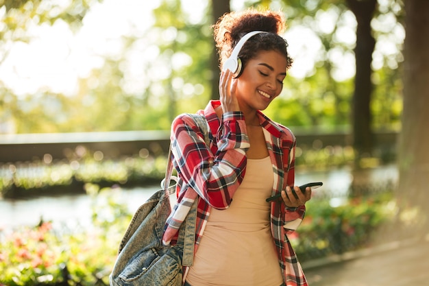 Cheerful young african woman walking outdoors