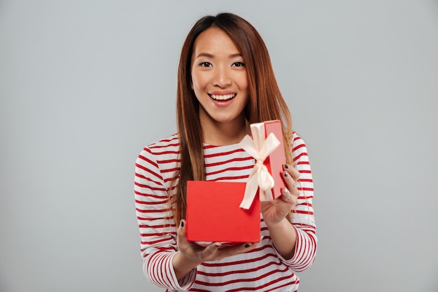 Cheerful young asian lady standing isolated