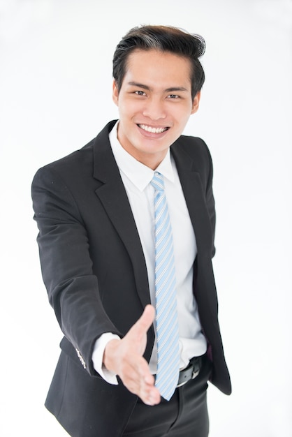 Cheerful young Asian man greeting business partner