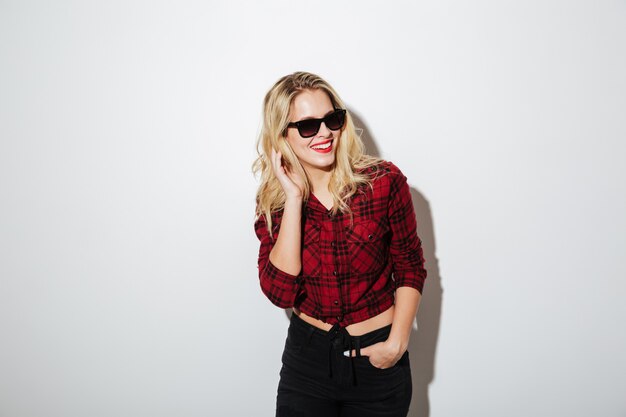 Cheerful young blonde woman wearing sunglasses