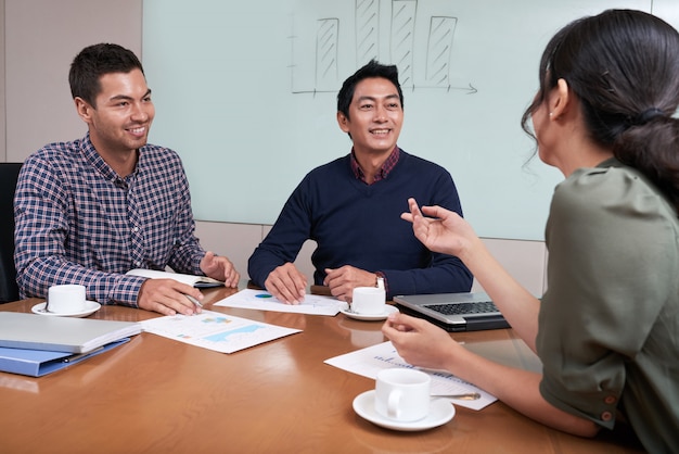 Free photo cheerful young business people having brainstorming session