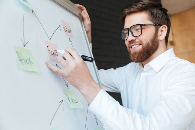 Cheerful young businessman write something