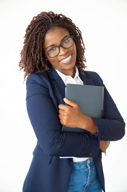 Cheerful young businesswoman holding folder