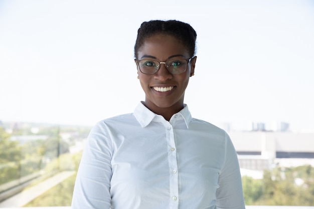 Free photo cheerful young businesswoman smiling at camera