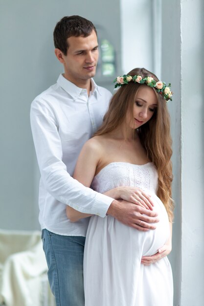 Cheerful young couple  dressed in white standing at home