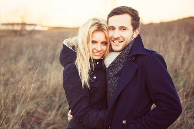 Cheerful young couple hugging outdoors