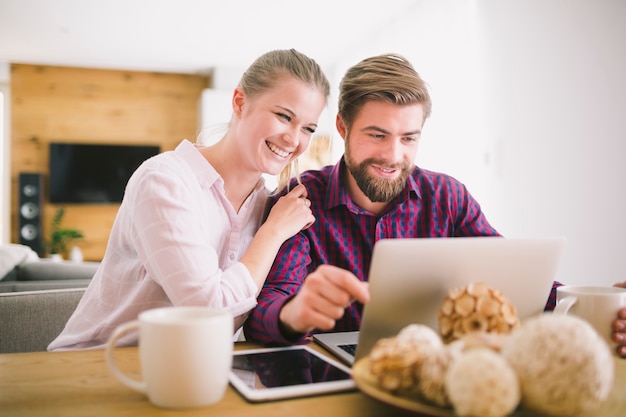 Cheerful young couple at laptop