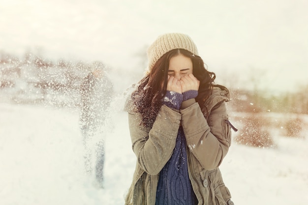 Cheerful young couple playing snowballs