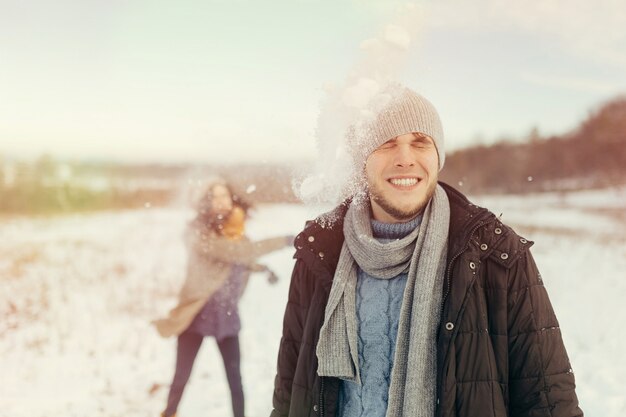 Веселая молодая пара играет в снежки