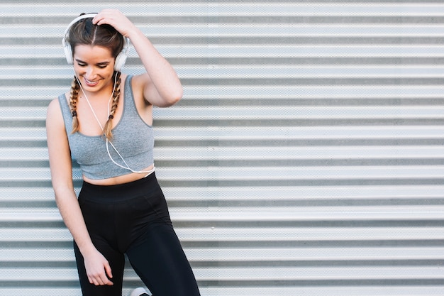Cheerful young fit woman in headphones