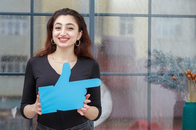 Cheerful young lady holding hand sign and smiling High quality photo