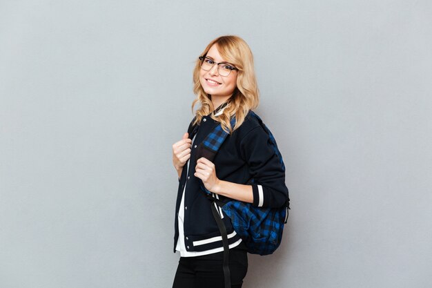 Cheerful young lady student with backpack