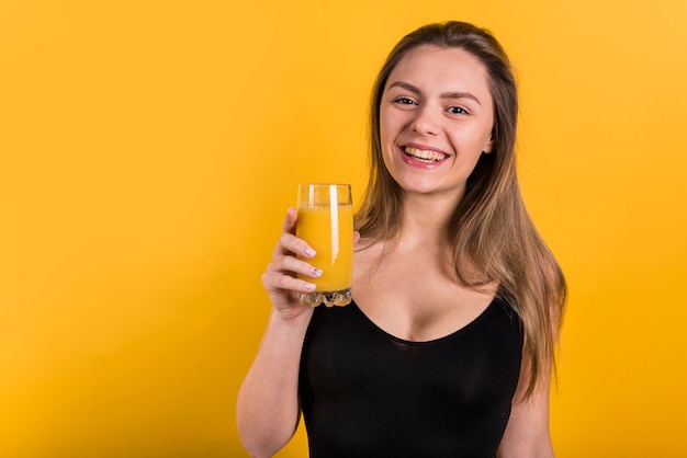 Cheerful young lady with glass of juice