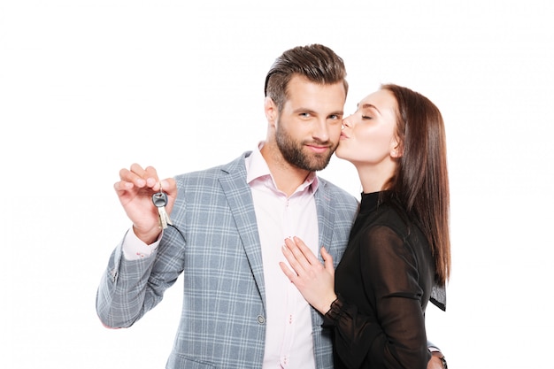 Free photo cheerful young loving couple holding keys.