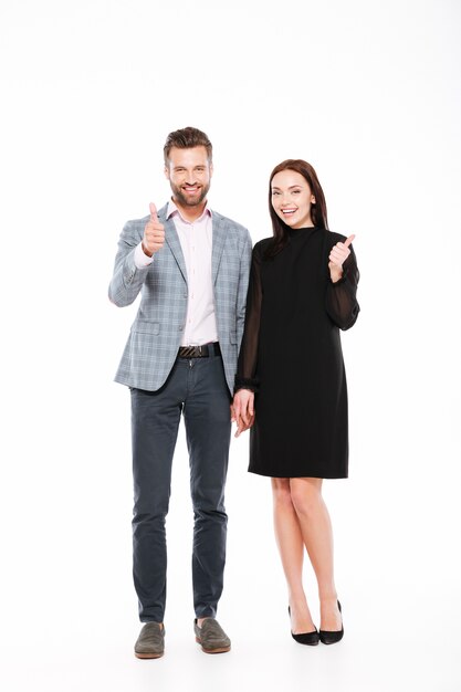 Cheerful young loving couple showing thumbs up.