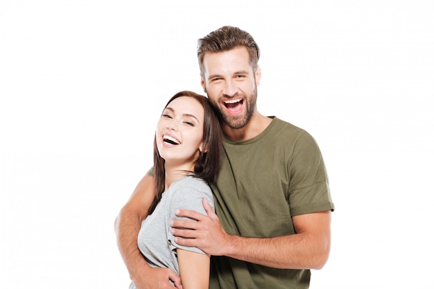 Free photo cheerful young loving couple standing isolated