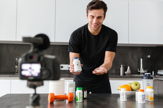 Cheerful young man filming his video blog episode