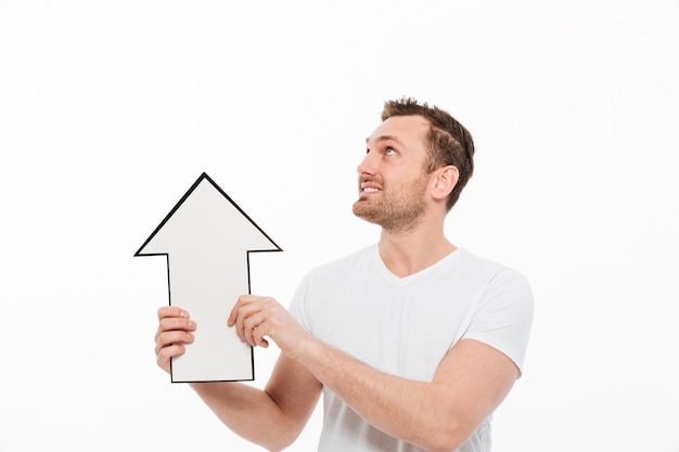 Cheerful young man holding arrow while looking aside.