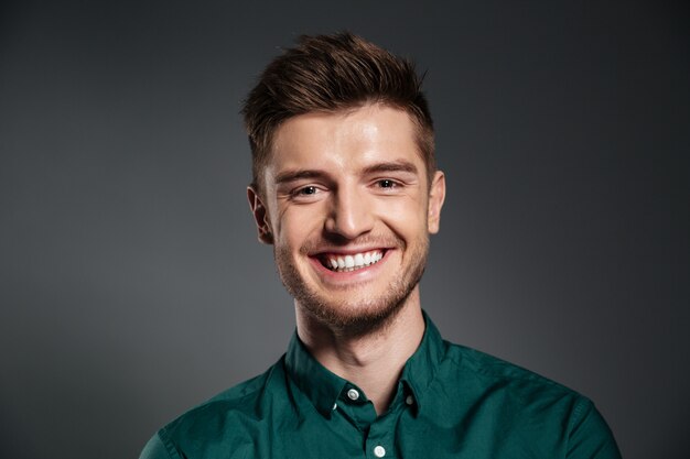 Cheerful young man posing isolated over grey