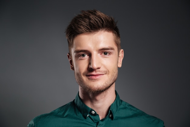 Cheerful young man posing isolated over grey