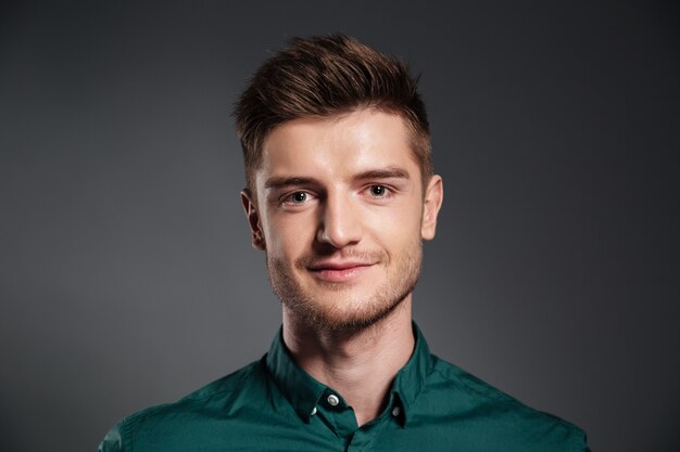 Cheerful young man posing isolated over grey