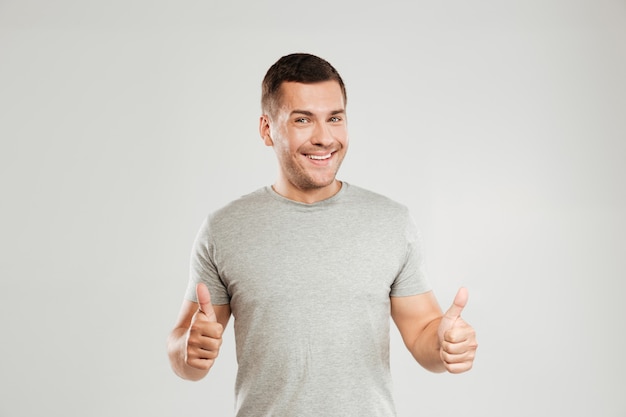 Cheerful young man showing thumbs up.