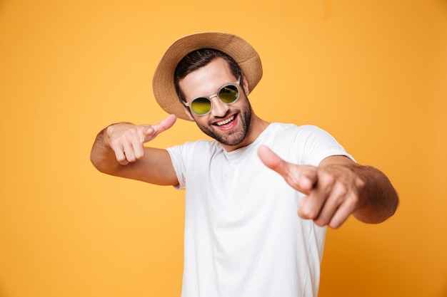 Cheerful young man standing isolated over orange wall