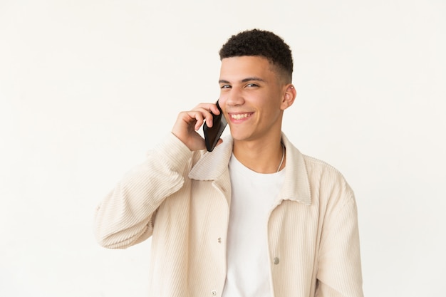 Cheerful young man talking by smartphone