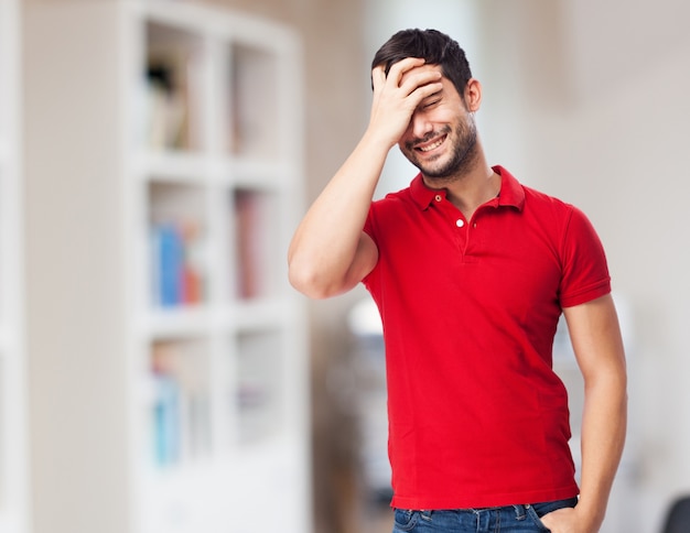 Cheerful young man touching his forehead