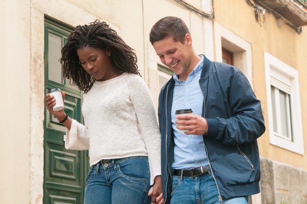 Cheerful young mix raced couple walking outdoors